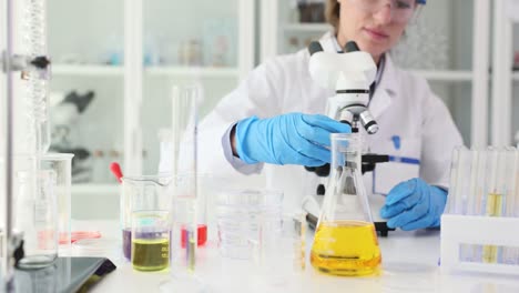 a scientist conducts an experiment in a laboratory using a microscope and various lab equipment