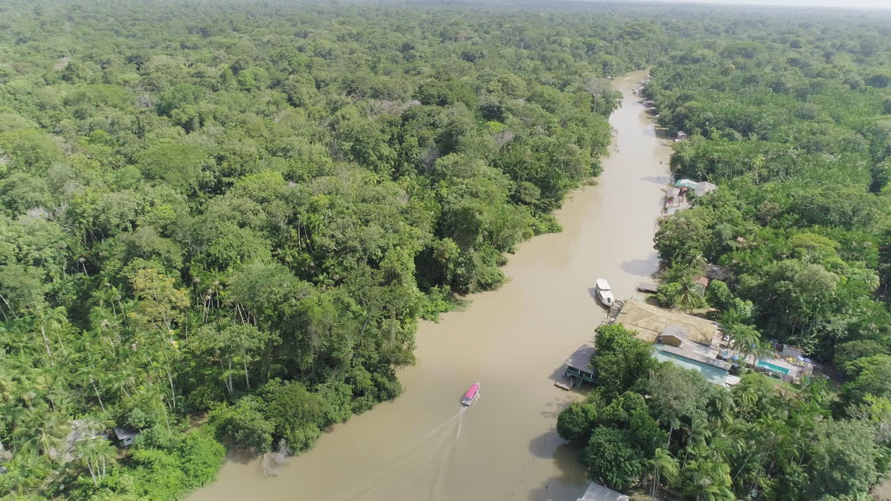toma aérea siguiendo el barco en el río amazónico dentro de la selva