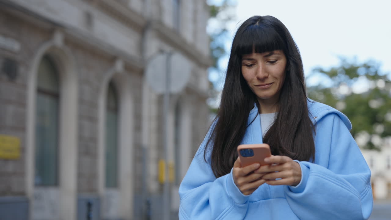Woman using mobile phone on the street