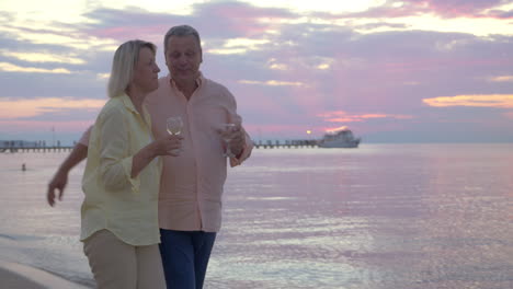 couple having romantic seaside walk with wine