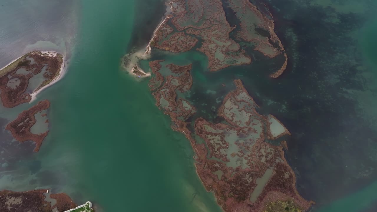 Aerial capture of a serene blue lake surrounded by greenery, Ksamil