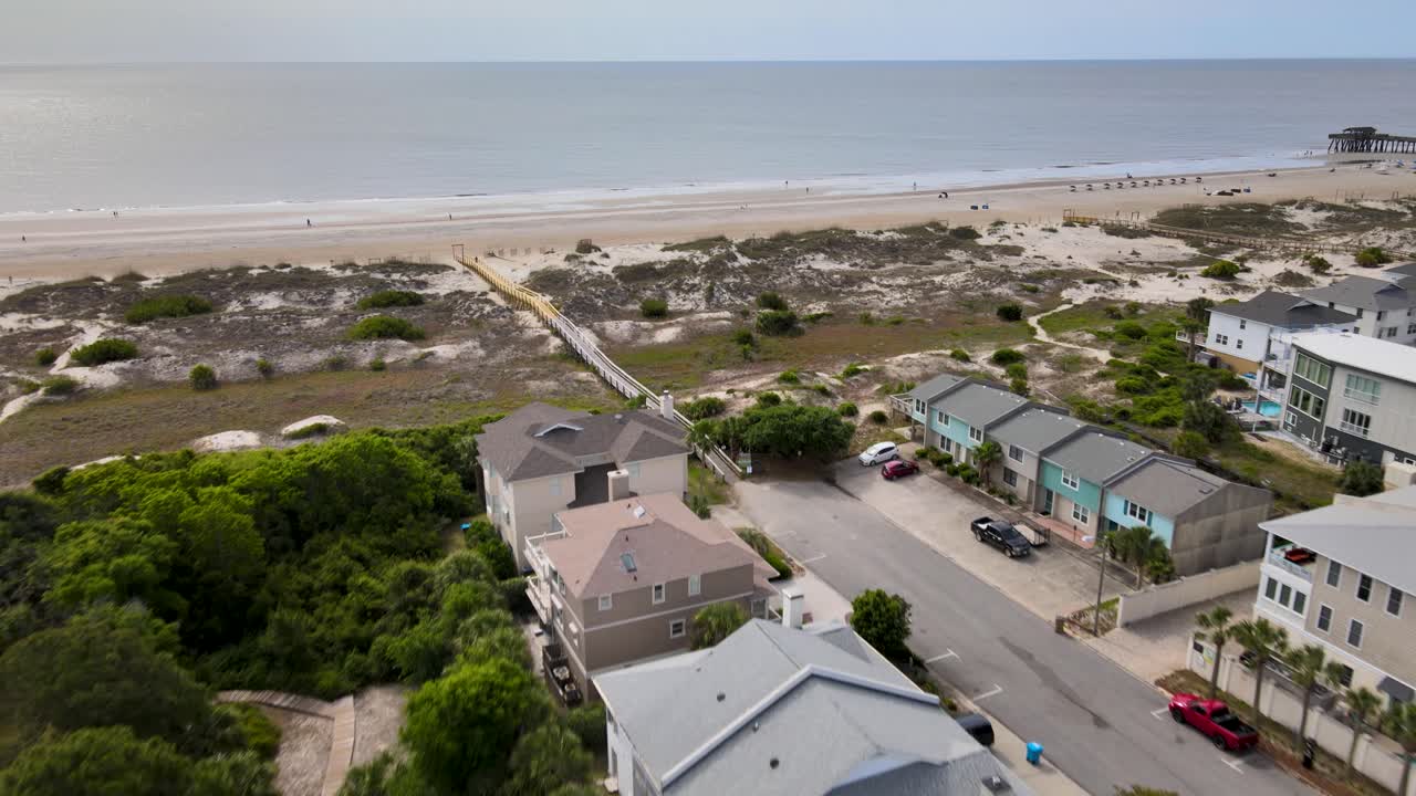 Case sulla spiaggia accanto a una spiaggia con una passerella recentemente riparata