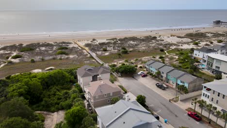 beach houses next to a beach with a boardwalk that has been recently repaired