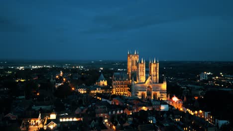 Aerial-drone-video-captures-the-renowned-Lincoln-Cathedral-in-Lincolnshire,-UK,-at-dusk,-showcasing-its-majestic-Gothic-architecture-with-illumination