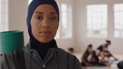 portrait beautiful yoga woman smiling confidently muslim female enjoying healthy lifestyle wearing headscarf with people practicing in fitness studio background