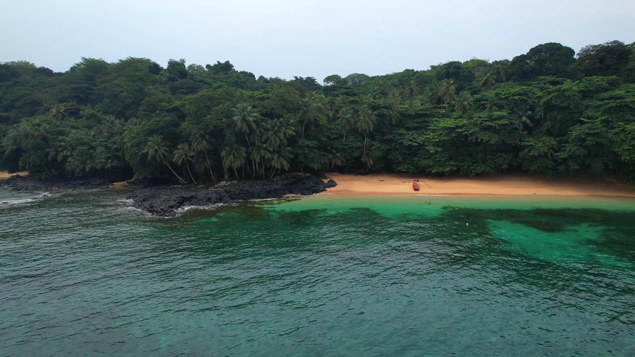 Flying sideways and low along the sea with Margarida beach in the background as well as the wonderful coast of Principe Island, São Tomé,Africa