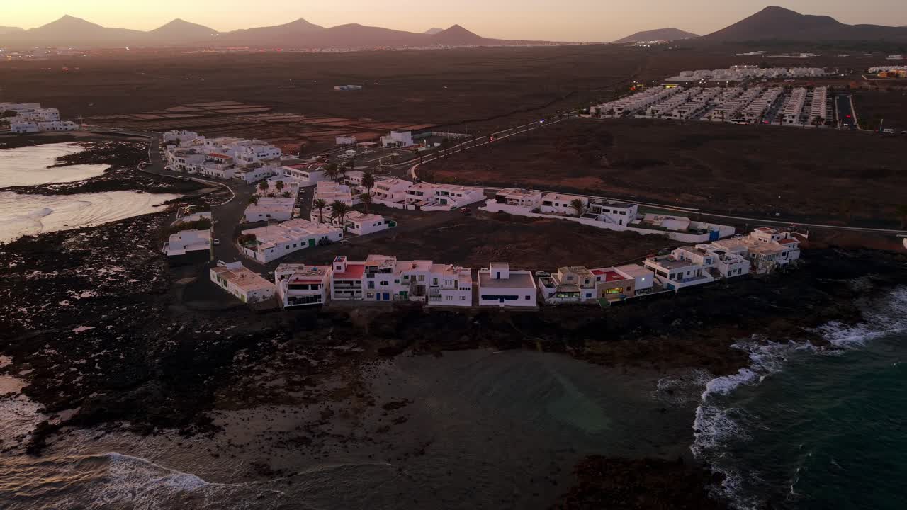 Vista aerea di Costa Teguise, Lanzarote, Isole Canarie, che mostra l'architettura costiera e le onde dell'oceano.