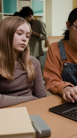 young women studying together in a classroom or library