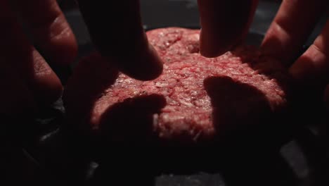 preparing a raw hamburger patty