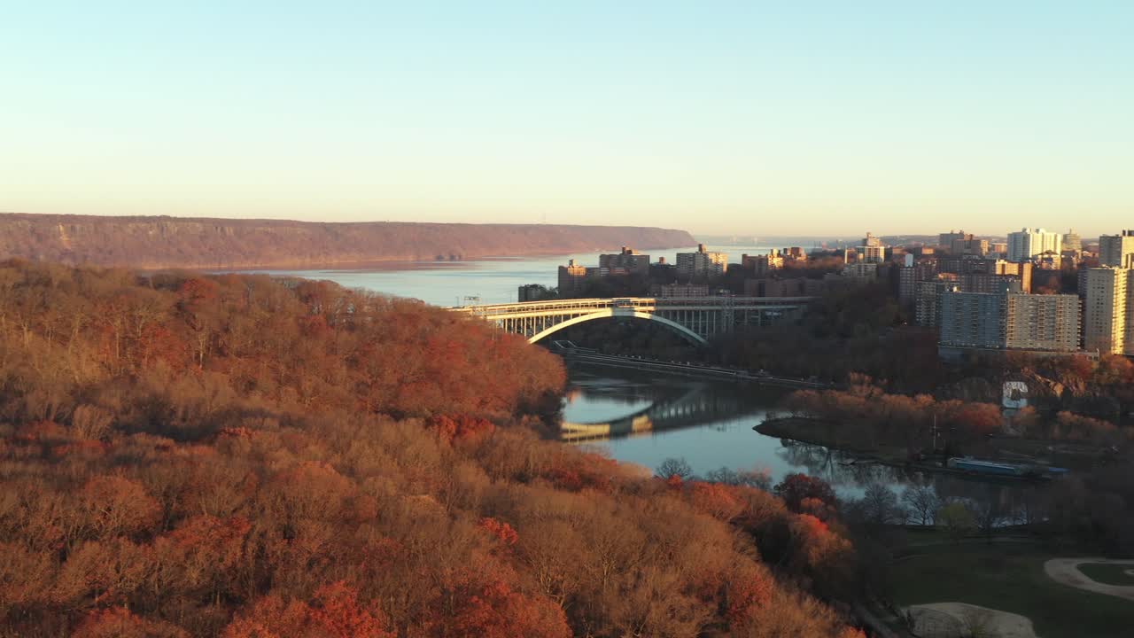 bandeja de sedimentación aérea sobre la punta de manhattan con el puente hudson y el río visibles en la hora dorada, inwood park y spuyten duyvil