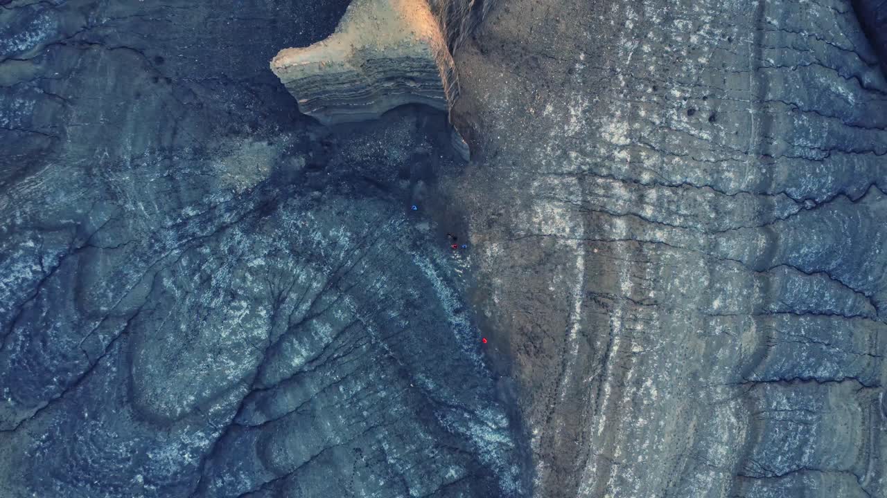excursionista irreconocible de pie en un terreno rocoso en un valle volcánico durante el viaje