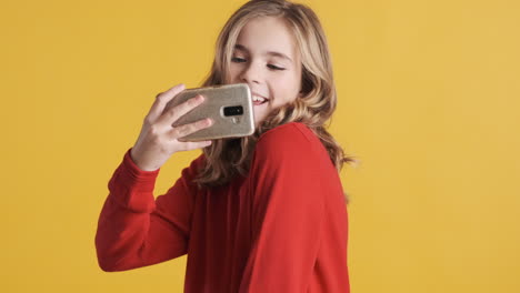 una adolescente caucásica tomando fotos con su teléfono inteligente.