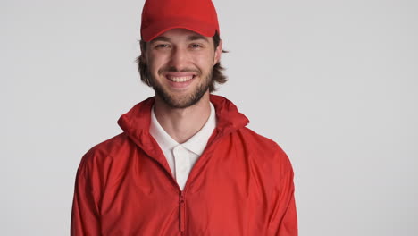 Caucasian-delivery-man-in-front-of-camera-on-white-background.