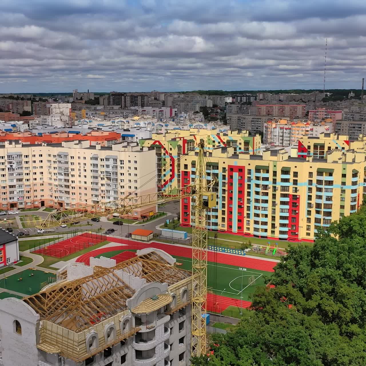 Construction site shot from above. Aerial view of new residential building under construction. High crane at the building