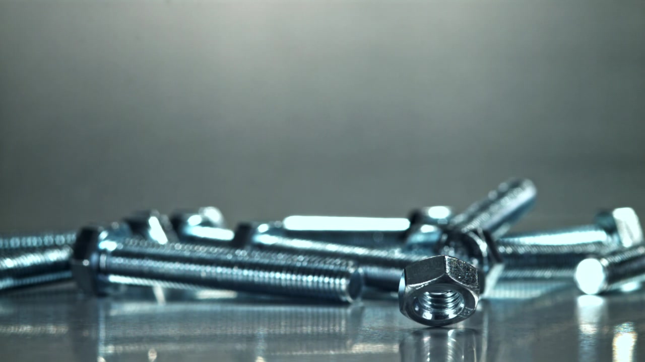 Shiny Metal Nut Spinning on a Reflective Surface
