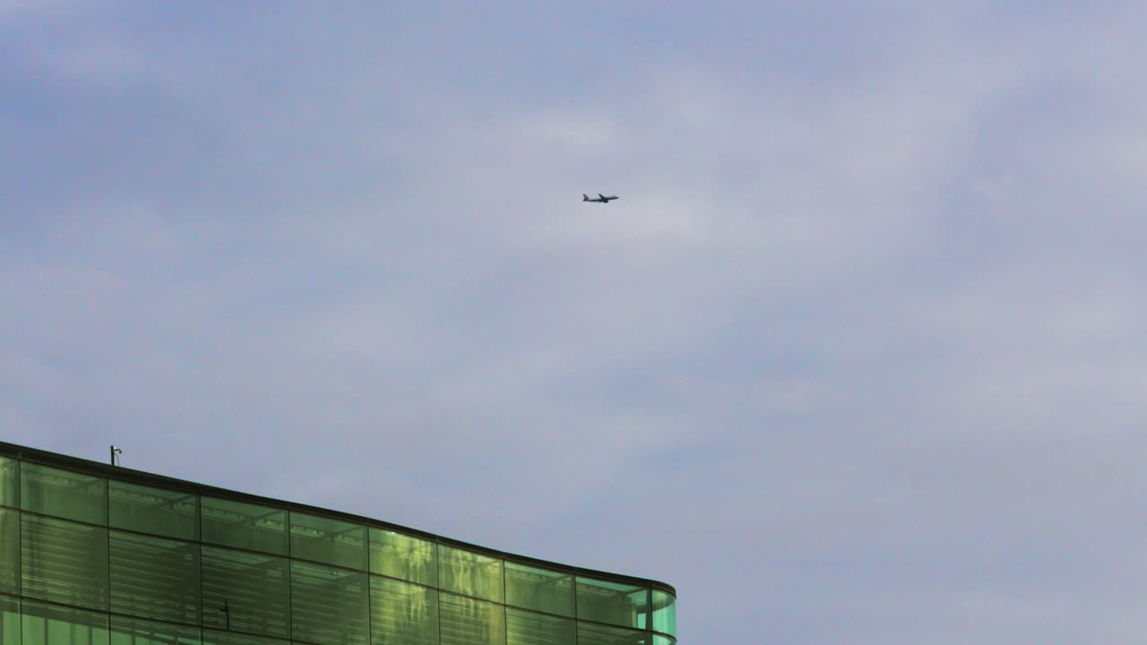 Plane Flying Above Building in London Leaving City Airport Heading to Destination