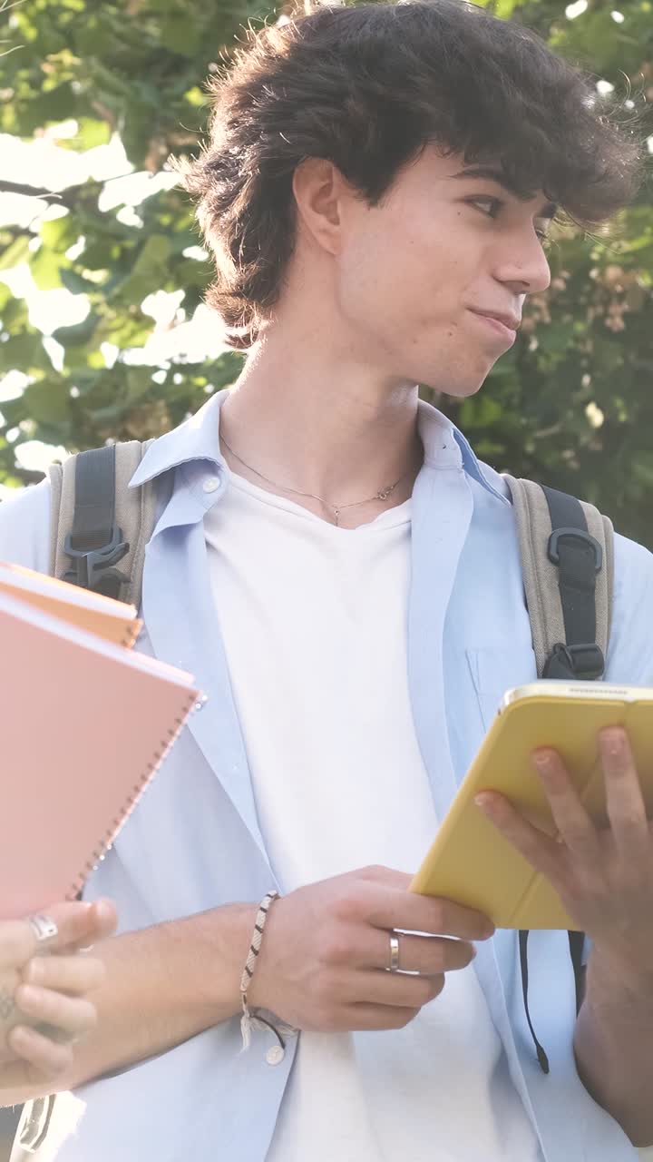 Studenti universitari impegnati in una discussione mentre mostrano lo schermo di un tablet all'aperto