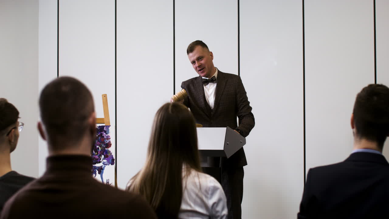 personas en una sesión de subasta de arte