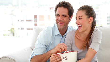 Couple-watching-tv-and-eating-popcorn-on-the-couch