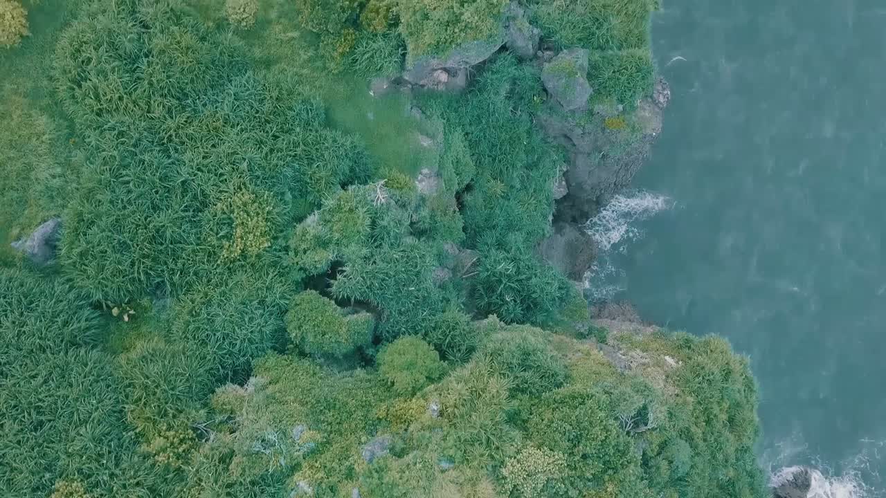 Cinematic aerial drone view of a picturesque landscape of ocean meeting mountains in Batanes, Philippines