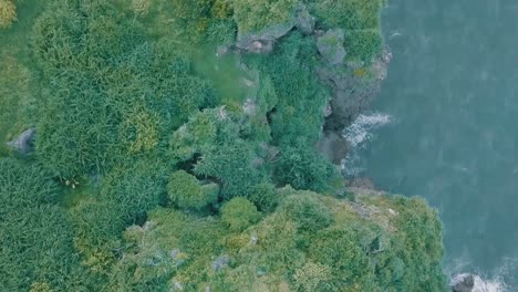 Cinematic-aerial-drone-view-of-a-picturesque-landscape-of-ocean-meeting-mountains-in-Batanes,-Philippines