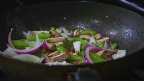 panning into vegetables in pan while cooking