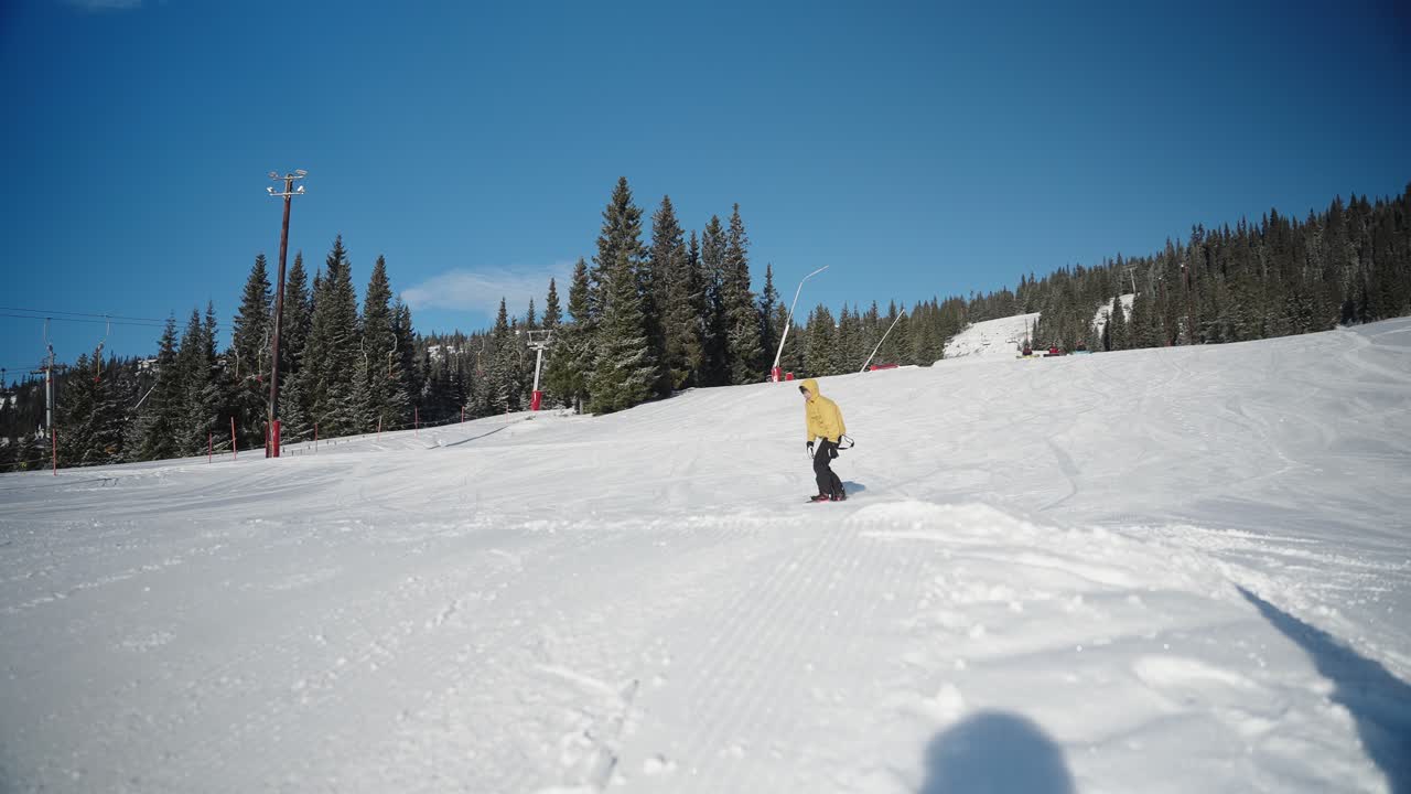 cámara lenta de 4k de snowboarder haciendo un salto en la colina de nieve en el parque de diversión en la estación de esquí en un día soleado con cielo azul en noruega