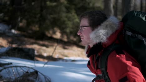 close up profile follow shot of man walking through snowy forest