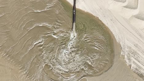 vista aérea directa con avión no tripulado de un proceso de dragado en la playa