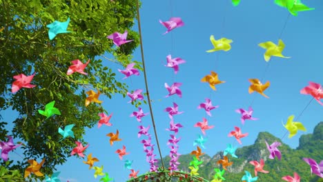 thousands of colorful pinwheels spinning overhead on a sunny windy day