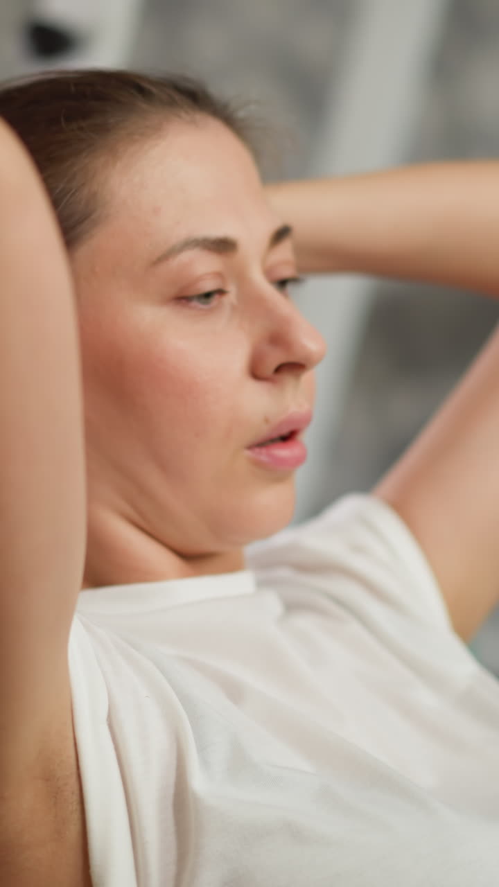 женщина тренируется с фитнес-болом дома. расслабленная дама в спортивной одежде любит заниматься фитболом в тренажерном зале. красивая женщина растягивает позвоночник на тренировках