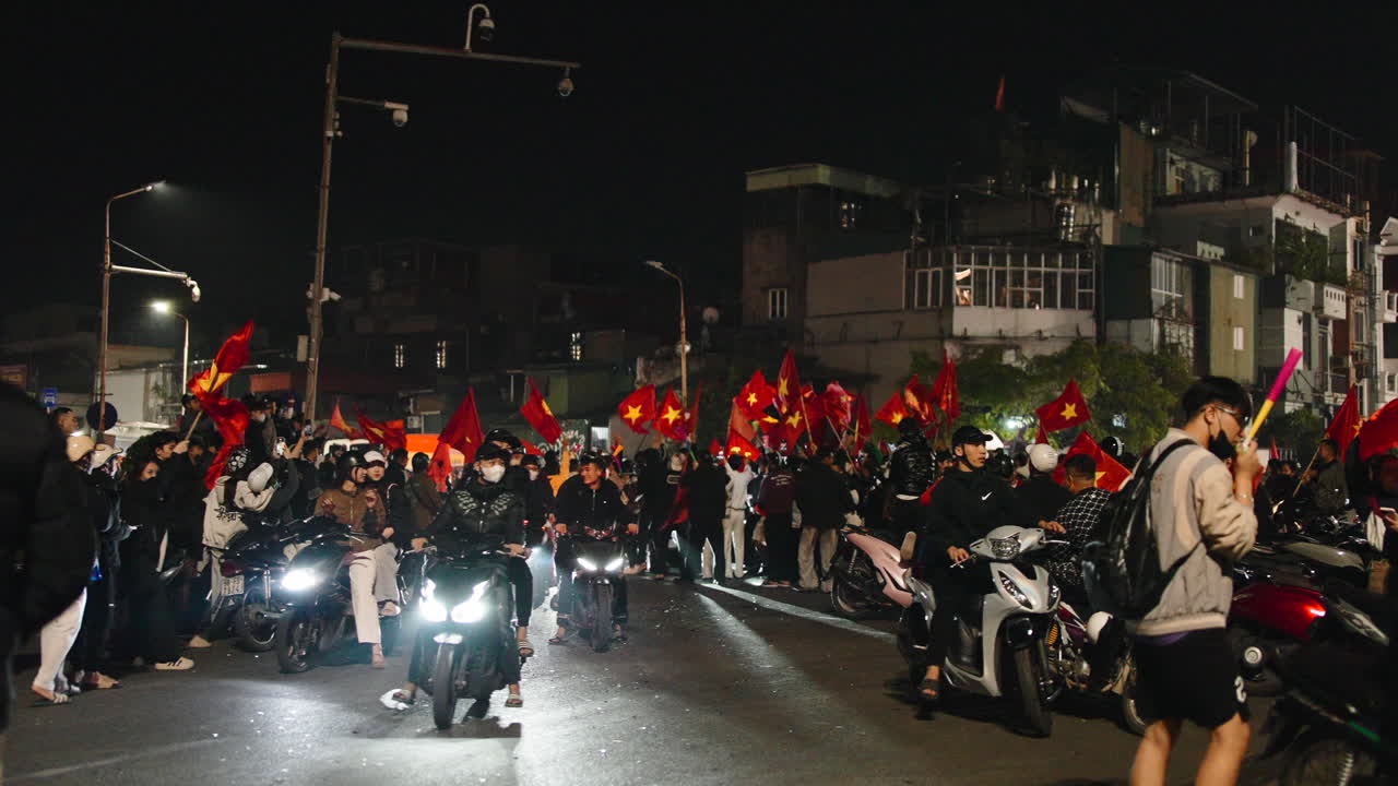 Festa notturna in strada con bandiere e moto
