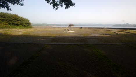 Extra-wide-shot-of-Carsington-Water-overgrown-viewing-area-with-the-Water-Valve-Tower,-Draw-Off-Tower-in-the-Background