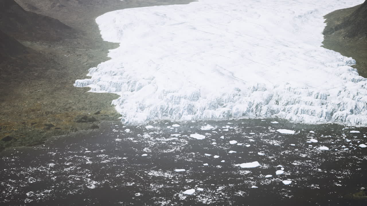 Ice melt reveals dark waters beneath glacier in a remote mountainous region