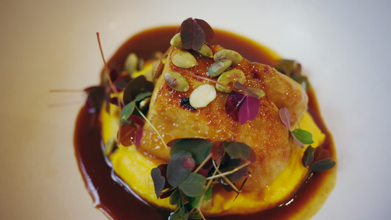 Elegant fine dining dish with sauce, microgreens, and seeds