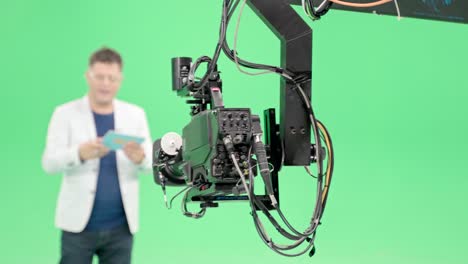 film crew in green studio shooting video. chroma - technology of combining two or more images or frames in single composition. cameraman, director, crew. filmmaking industry.