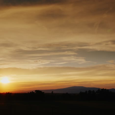 Schöner-Sonnenuntergang-Auf-Dem-Land-Und-Berge-Im-Hintergrund-3