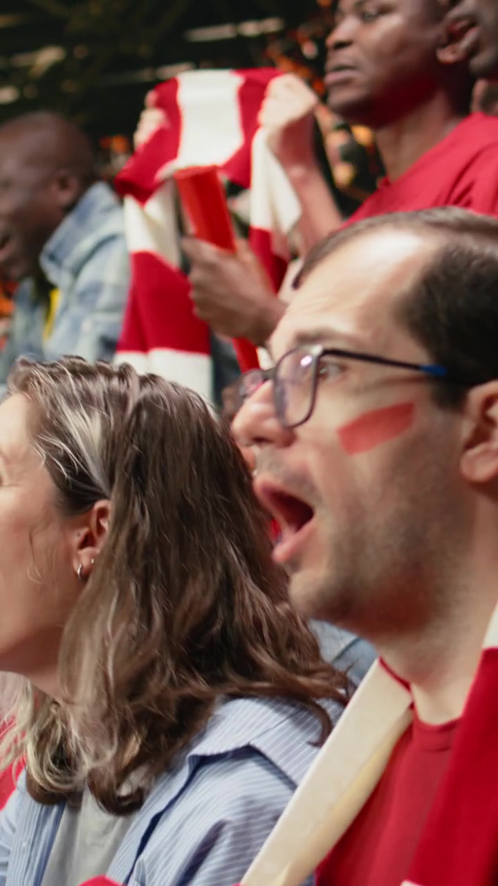 Vertical Video Passionate woman football supporter cheering with red team crowd