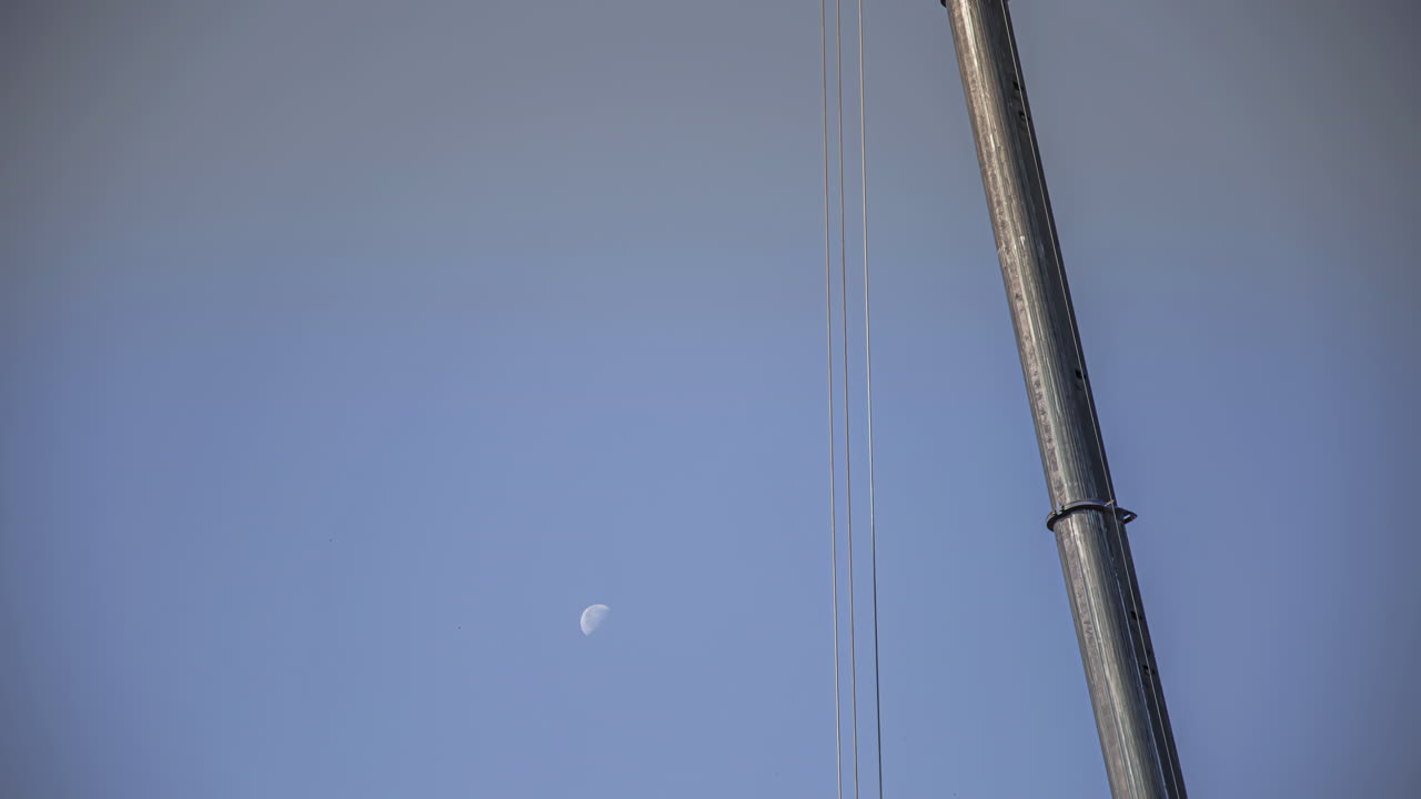 아침 시간 동안 빠르게 움직이는 달에서 건설 현장에서 작업하는 크레인의 타임랩스 샷