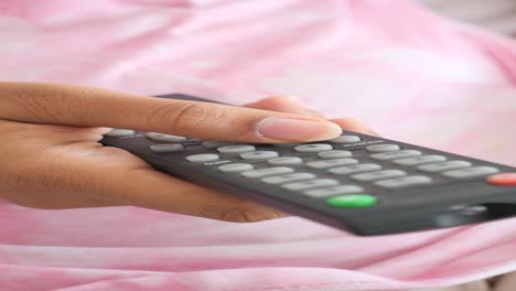 close up of hand holding a tv remote