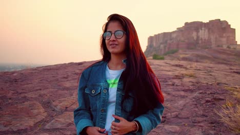 indian girl posing for a picture at a famous tourist place in jodhpur