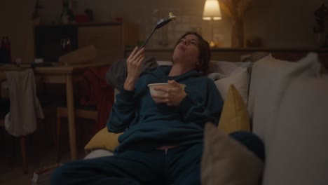 mujer comiendo en el sofá en casa