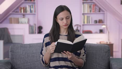 chica india leyendo un libro y bebiendo café
