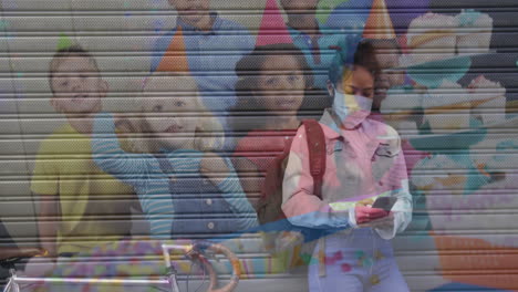 mujer con máscara facial usando un teléfono inteligente contra niños animando en una fiesta de cumpleaños