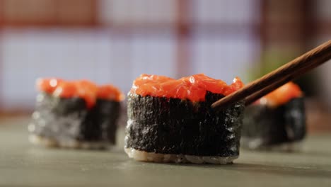 salmon sushi roll with chopsticks