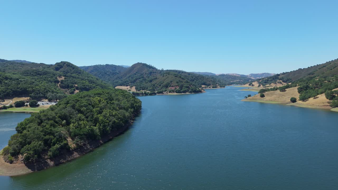 An aerial zoom in shot captures Uvas Reservoir’s serene layout, where rolling foothills taper into tranquil water