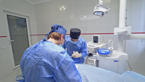 specialists treating patient's teeth. dentist with his assistant working in dental office. treatment of teeth in a modern clinic.