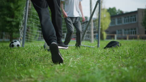 a close-up of a soccer ball is kicked into the goal post, as the goalkeeper jumps and rests on the ball from behind