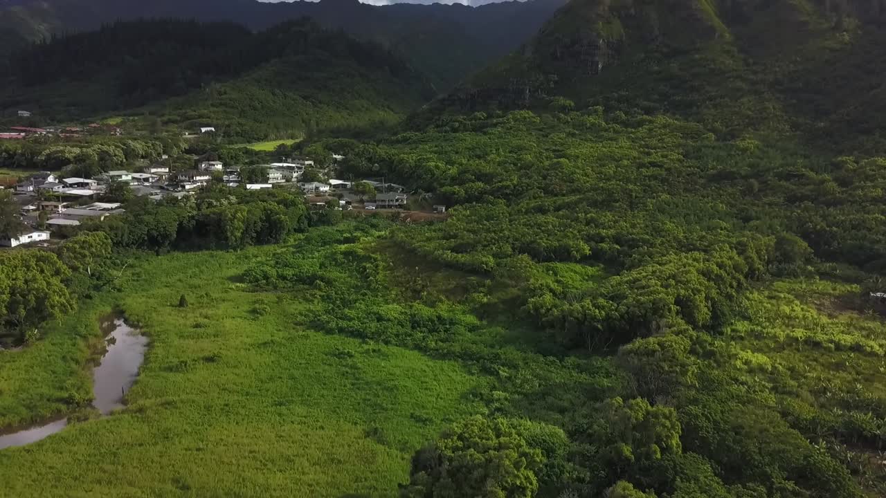 Tilt-pan aerial revealing Oahu’s North Shore mountains, showcasing lush green peaks, tropical landscapes, and breathtaking island views. Perfect for travel, nature, and scenic content.