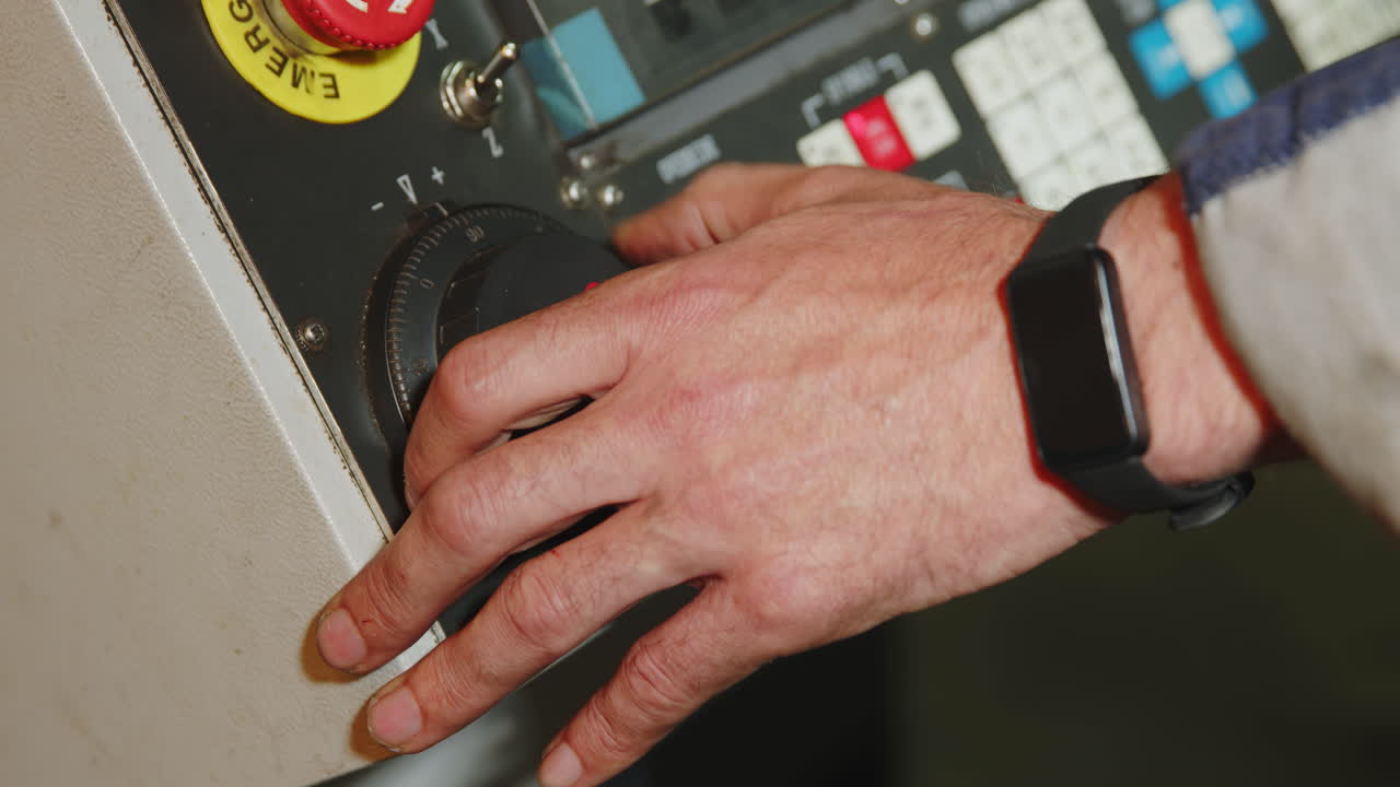 trabajador que ajusta los controles de la máquina